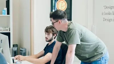 迈克和汤姆在汤姆的办公桌前做一些工作